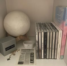 there are many cds on the shelf next to each other and a white ball in the corner