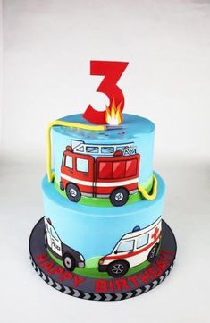 a three tiered birthday cake with firetruck and ambulances on it