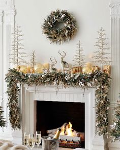 a living room decorated for christmas with candles and wreaths on the fireplace mantel