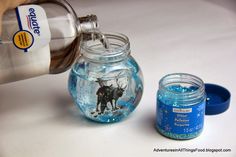 a person pours water into a jar filled with blue liquid