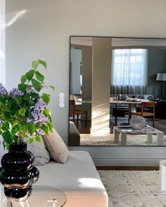 a living room filled with furniture and a large mirror