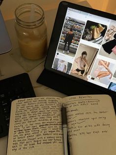 an open book sitting on top of a table next to a laptop computer