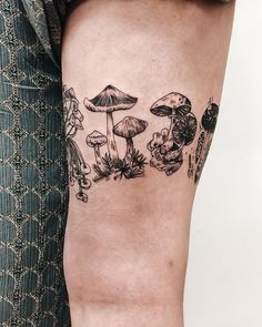 a woman's leg with mushrooms and flowers on it