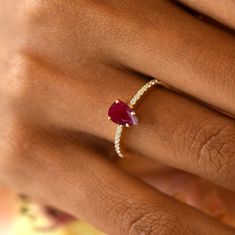 a woman's hand with a diamond and ruby ring