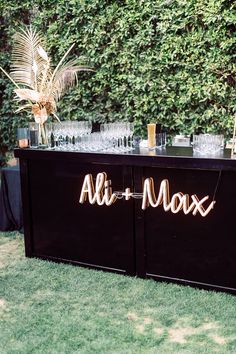 an outdoor bar set up with wine glasses and palm trees