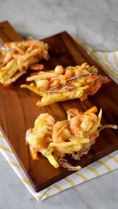 some food is sitting on a wooden cutting board