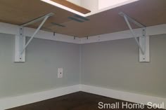 an empty room with no one in it and some brackets on the wall above them