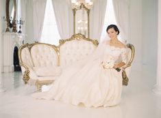 a woman in a wedding dress sitting on a couch