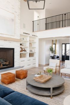 a living room with couches, chairs and a fire place in the middle of it