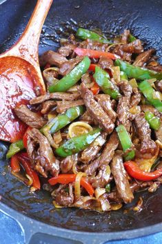 beef stir fry with peppers and onions in a skillet