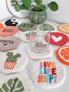 several crocheted coasters are arranged on a table next to a potted plant