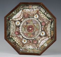 an intricately decorated wooden box with flowers and leaves on it's sides, in the shape of a hexagon