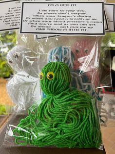 there is a green yarn octopus in the bag on the table next to it's instructions