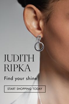 A woman with tan skin and brunette hair wearing sterling silver dangle earrings against a grey background. Shine Bright, Silver Fashion