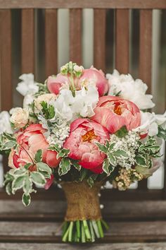 a bouquet of flowers sitting on top of a wooden bench