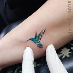 a small hummingbird tattoo on the arm