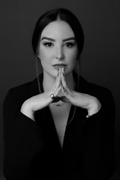 black and white photograph of a woman with her hands folded in front of her face