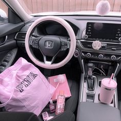 the interior of a car with pink accessories and items in it's center console