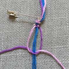 a pair of scissors are hooked up to a piece of yarn