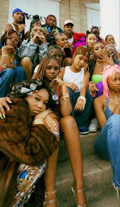 a group of young people sitting on the steps posing for a photo with each other