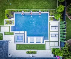 an aerial view of a pool surrounded by grass