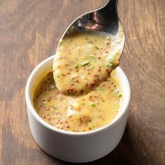 a spoon full of soup on top of a wooden table