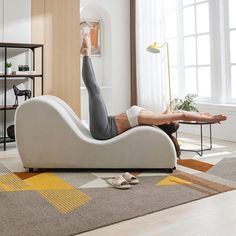 a man laying on top of a couch in a living room