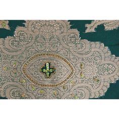 an intricately designed piece of cloth with green beads and sequins on it