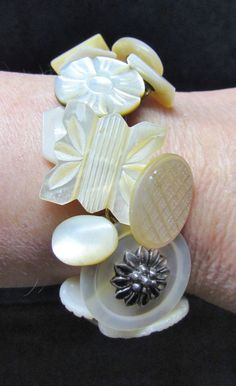 a woman's arm with a bracelet made out of buttons and beads