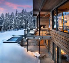 a house in the snow with a hot tub next to it