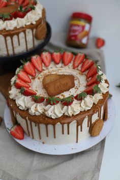 two cakes sitting on top of a white plate covered in frosting and strawberries