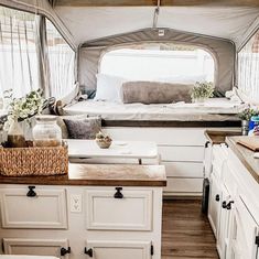 the inside of a camper with lots of storage space and white cabinets in it