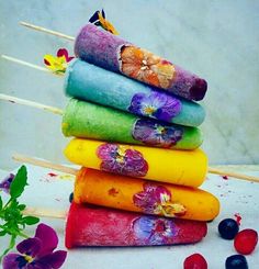 a stack of colorfully dyed cottons sitting on top of each other next to flowers