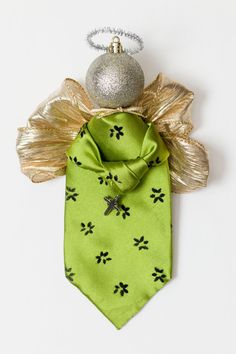 a green tie with black flowers on it and a silver ornament