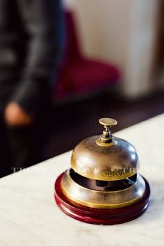 a bell sitting on top of a white table next to a red and black chair