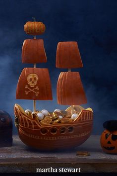 a pirate ship with pumpkins on the side and other items around it, including a jack - o'- lantern