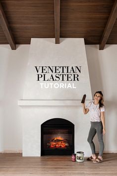 a woman standing in front of a fire place