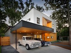 a white truck parked in front of a large house with two cars under the garage