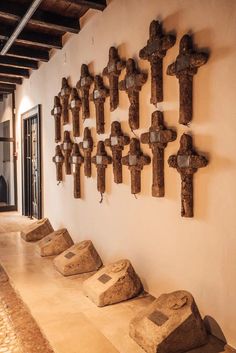 several crosses are mounted on the wall in front of a hallway with tile flooring