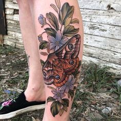 a woman's leg with a butterfly and flowers on it