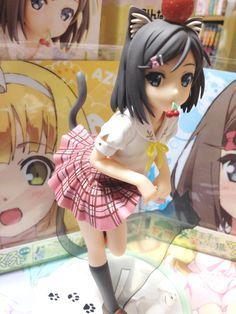 an anime doll is posed in front of some pictures