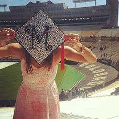 a woman in a pink dress holding up a graduation cap with the letter n on it