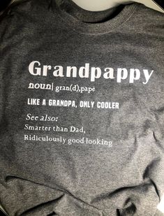 "Such a fun shirt to gift a special Grandpa this Father's Day! This Grandpa Definition Shirt also would be great way to announce a baby to the new grandpa to be! **any name can be inserted Grandpa, Gramps, Papa, Pops, Grampie, Grandfather, Pop - you name it!! This is a super soft shirt - 50% Cotton 50% Polyester blend unisex cut shirt in dark heather gray. White lettering. Also available in black Please see the following size chart and order accordingly. Small - Length 28\", Width 18\" Medium - Funny Letter Print Tops For Gifts, Funny Letter Print Tops For Gift, Funny Letter Print Tops As Gifts, Funny Name Print Tops For Gifts, Funny Cotton Shirt Gift, Funny Text Print Tops As Gift, Funny Cotton Shirt As Gift, Funny Cotton Shirt As A Gift, Funny Shirt For Father's Day Gift