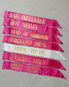 pink ribbons with gold lettering on them that say bad influence, hot mama, maid of dishonor, designated drunk, bride to be, dancing