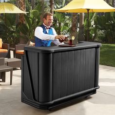 a man sitting at an outdoor bar with umbrellas in the backgroung