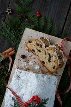 two pieces of bread sitting on top of a cutting board next to christmas greenery