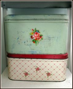 an old fashioned refrigerator with flowers painted on the front and bottom, sitting in a cabinet