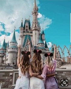 three girls standing in front of a castle