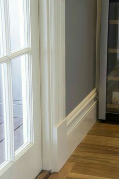 an empty room with wood floors and white trim