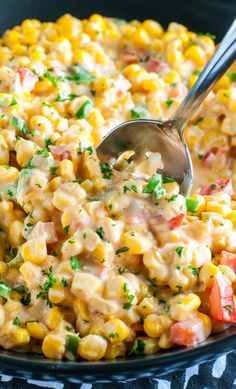 a large bowl filled with corn salad and a spoon in the middle, ready to be eaten